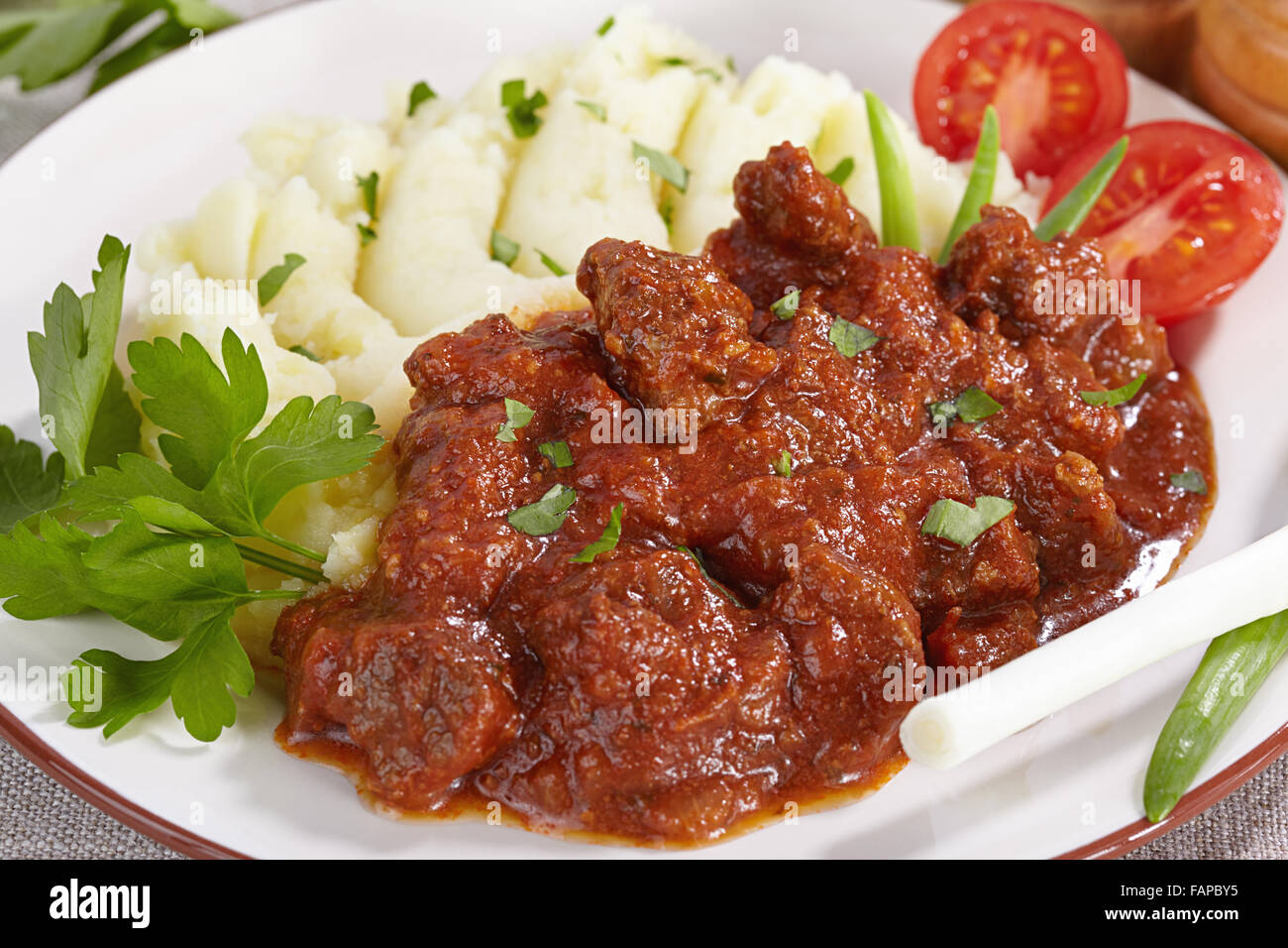 Goulash avec de la purée de pommes de terre et de tomate Banque D'Images