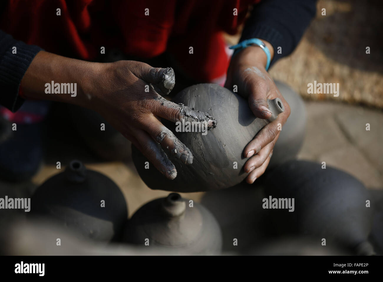 Bhaktapur, Népal. 3 janvier, 2016. Krishna Maya Prajapati un trente-année-vieille femme de Papanicolaou pots en argile à la place Pottery à Bhaktapur, Népal le dimanche, 3 janvier, 16. La façon traditionnelle de faire des pots en argile est bien connu au Népal. Comme l'équipement de machines ont progressé, il y en a quelques-uns qui continuent toujours à faire des pots en argile avec leurs mains. © Skanda Gautam/ZUMA/Alamy Fil Live News Banque D'Images