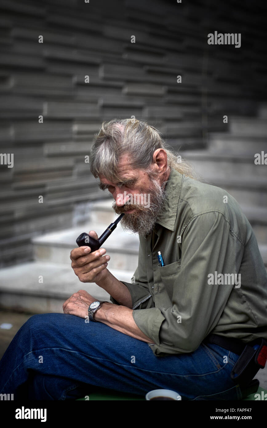 Fumeuse de pipe. Homme mûr fume un tuyau. Banque D'Images