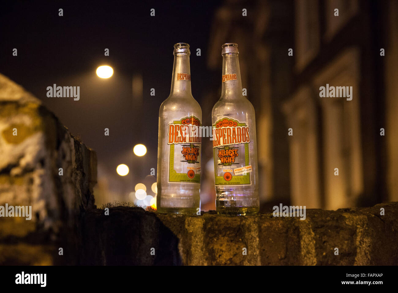 Deux bouteilles vides de bière blonde sur un mur dans la nuit Banque D'Images