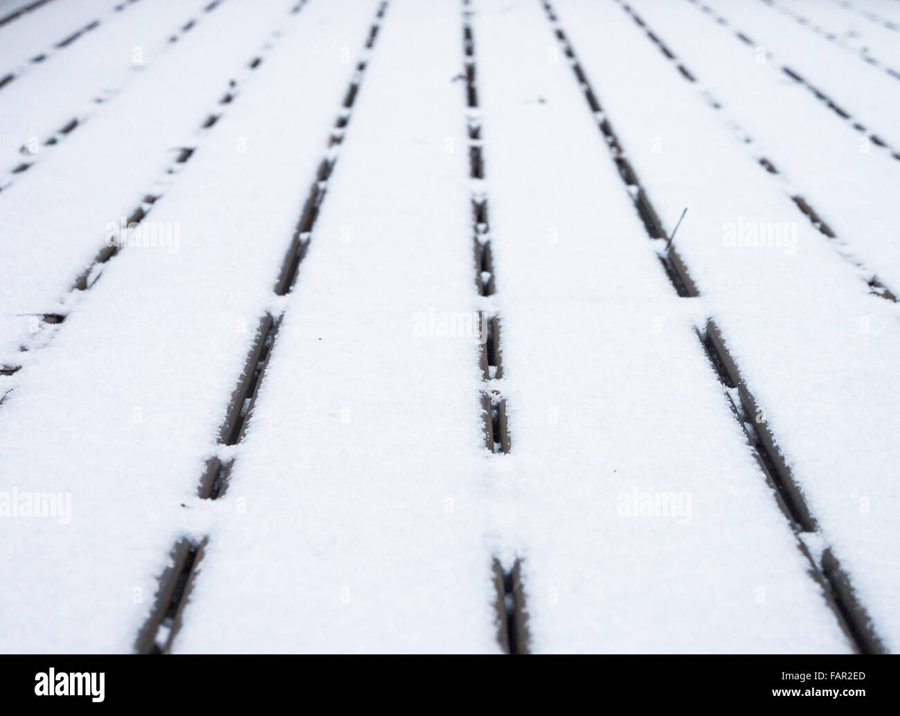 Terrasse en bois couverte de neige et de lignes convergentes avec une faible profondeur de champ. Banque D'Images