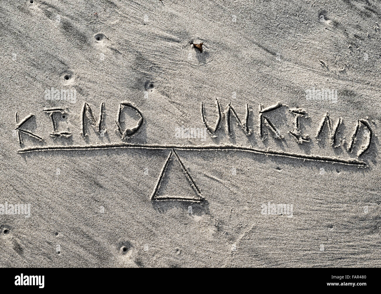 Un dessin d'une balançoire ou l'échelle dans le sable avec des mots gentils et méchant en équilibre. Banque D'Images