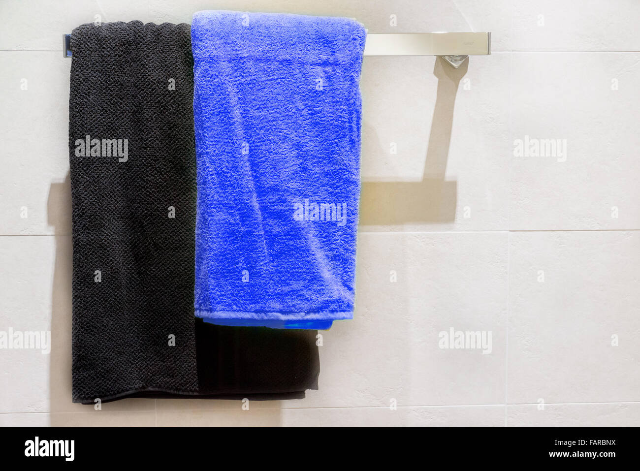 Noir et bleu sur le crochet de porte-serviettes dans la salle de bains Banque D'Images