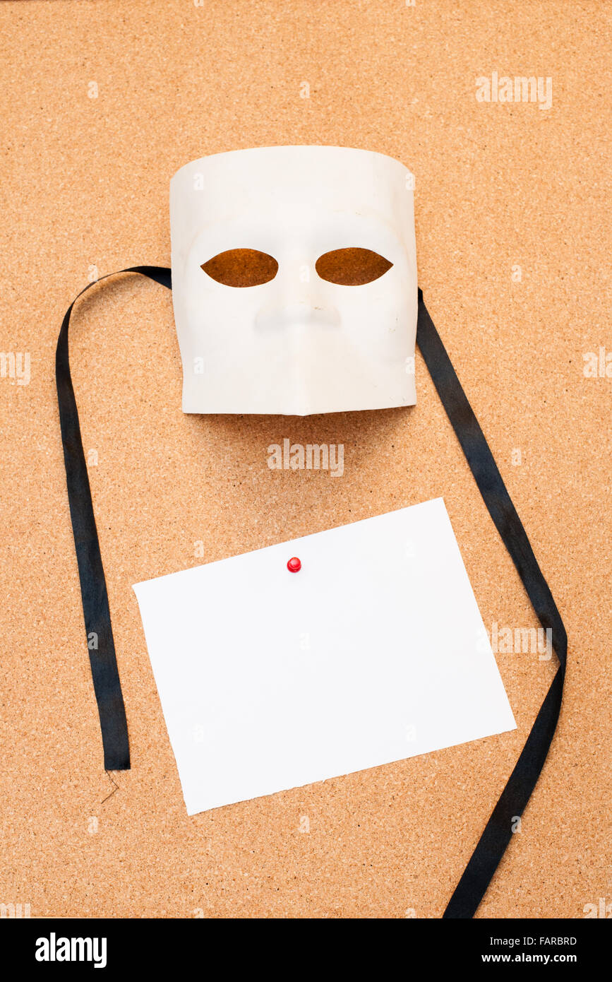 Masque blanc papier vide et épinglées sur le panneau de liège Banque D'Images