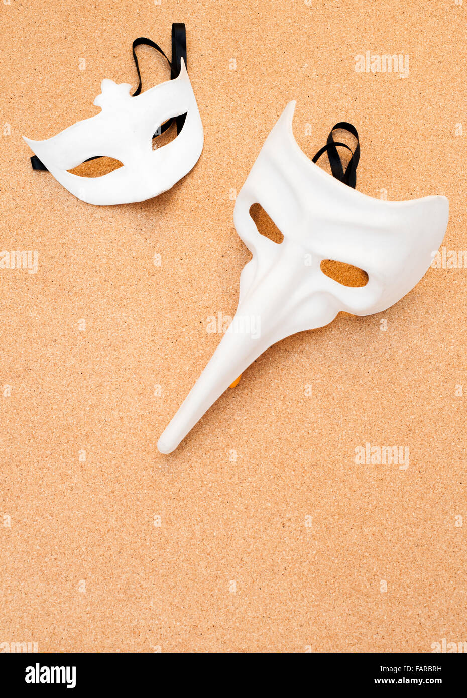 Deux différents masques de carnaval blanc sur fond de bois de liège Banque D'Images