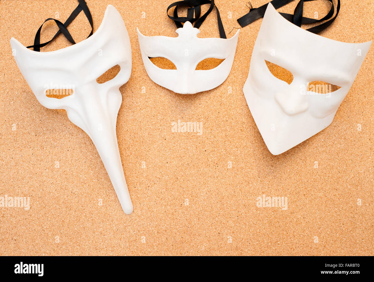 Trois différents masques de carnaval blanc sur fond de bois de liège Banque D'Images