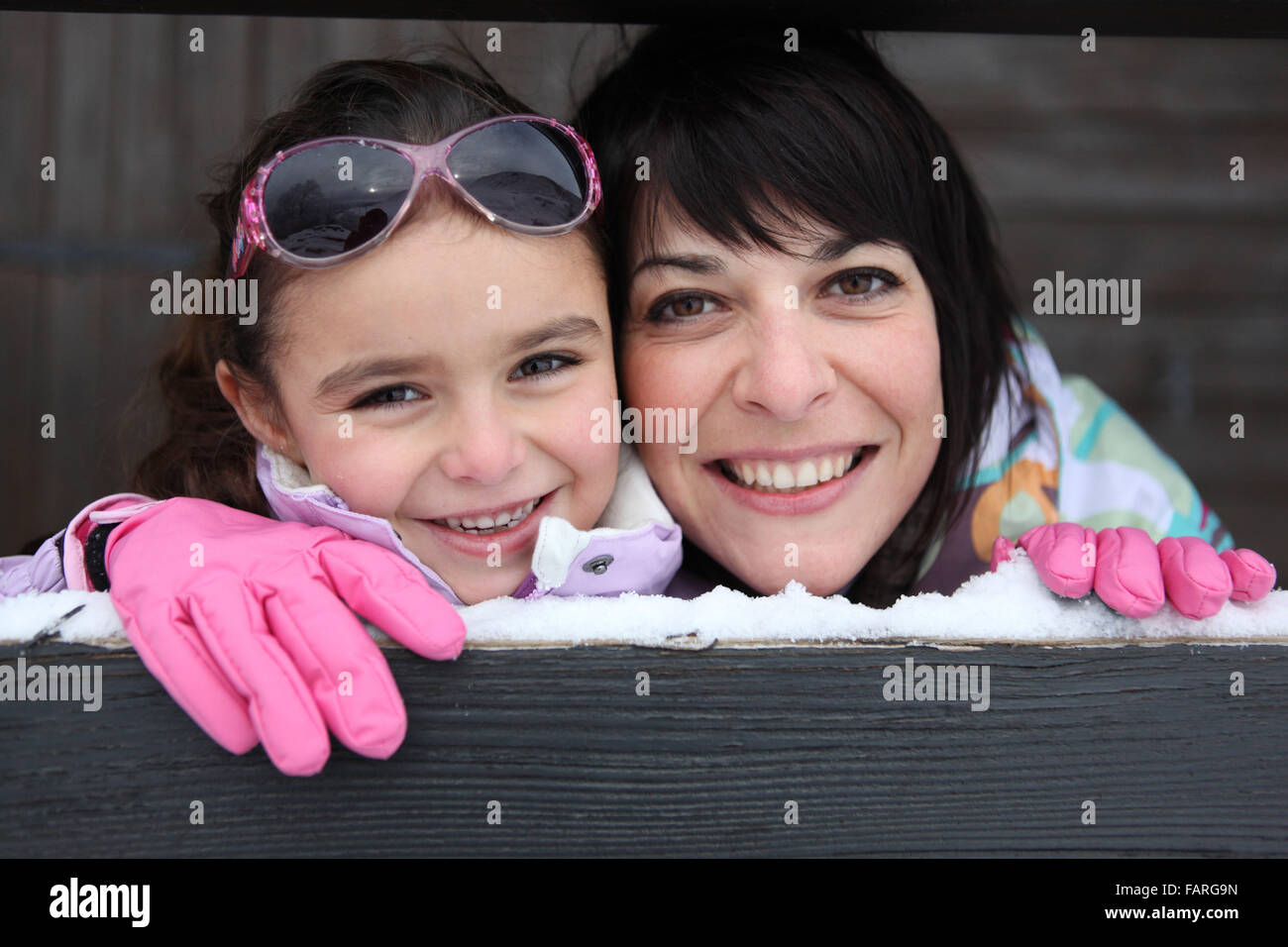 Mère et fille se tenait par leur maison de ski Banque D'Images