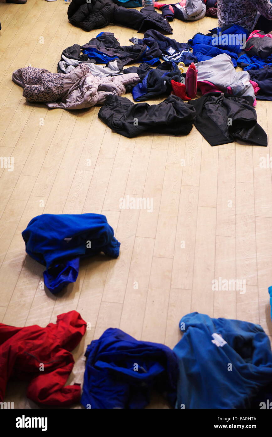 Pulls et manteaux laissés par les enfants dans une salle d'école au cours d'une assemblée générale à une école primaire Banque D'Images
