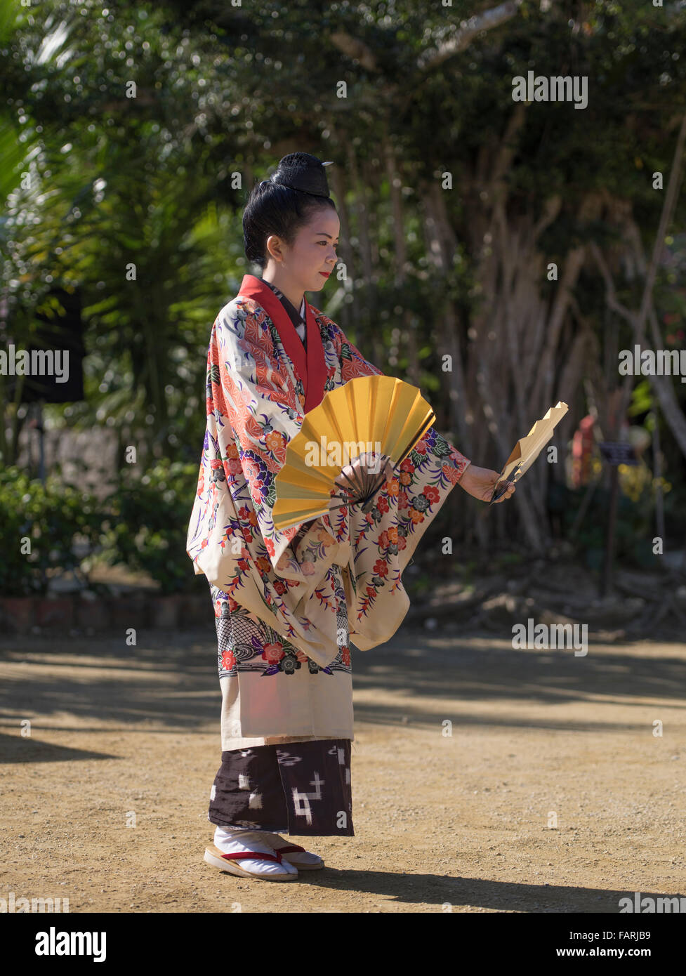 Femme en costume traditionnel d'Okinawa d'effectuer la danse du ventilateur, Ryukyu Mura, Okinawa, Japon Banque D'Images