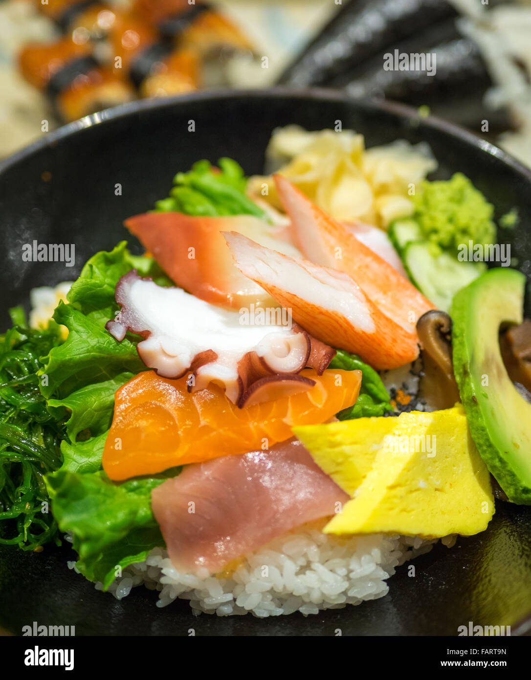 Un bol de chirashi (chirashizushi), qui se compose de riz sushi surmonté d'une variété de poisson cru et de légumes. Banque D'Images