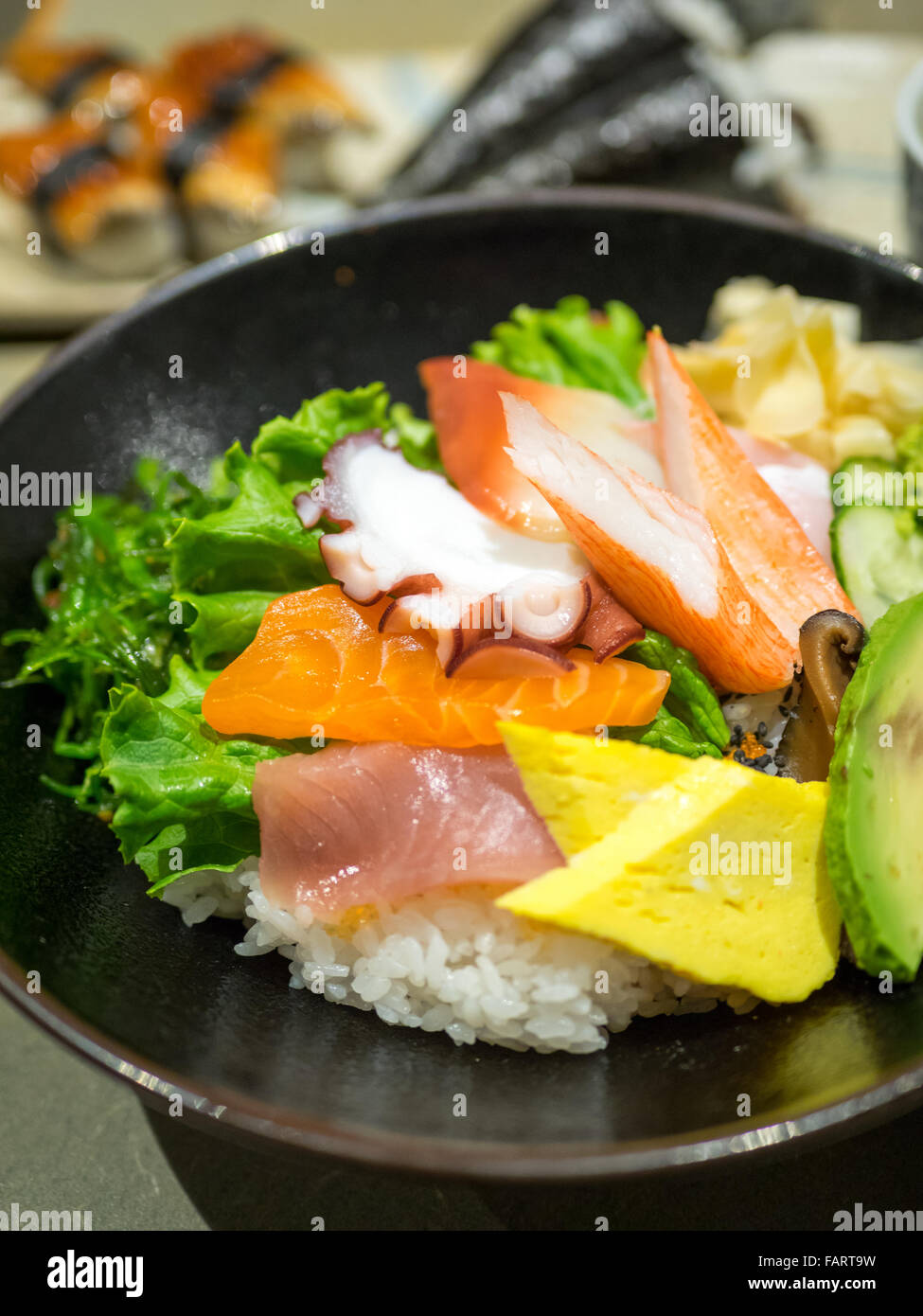 Un bol de chirashi (chirashizushi), qui se compose de riz sushi surmonté d'une variété de poisson cru et de légumes. Banque D'Images