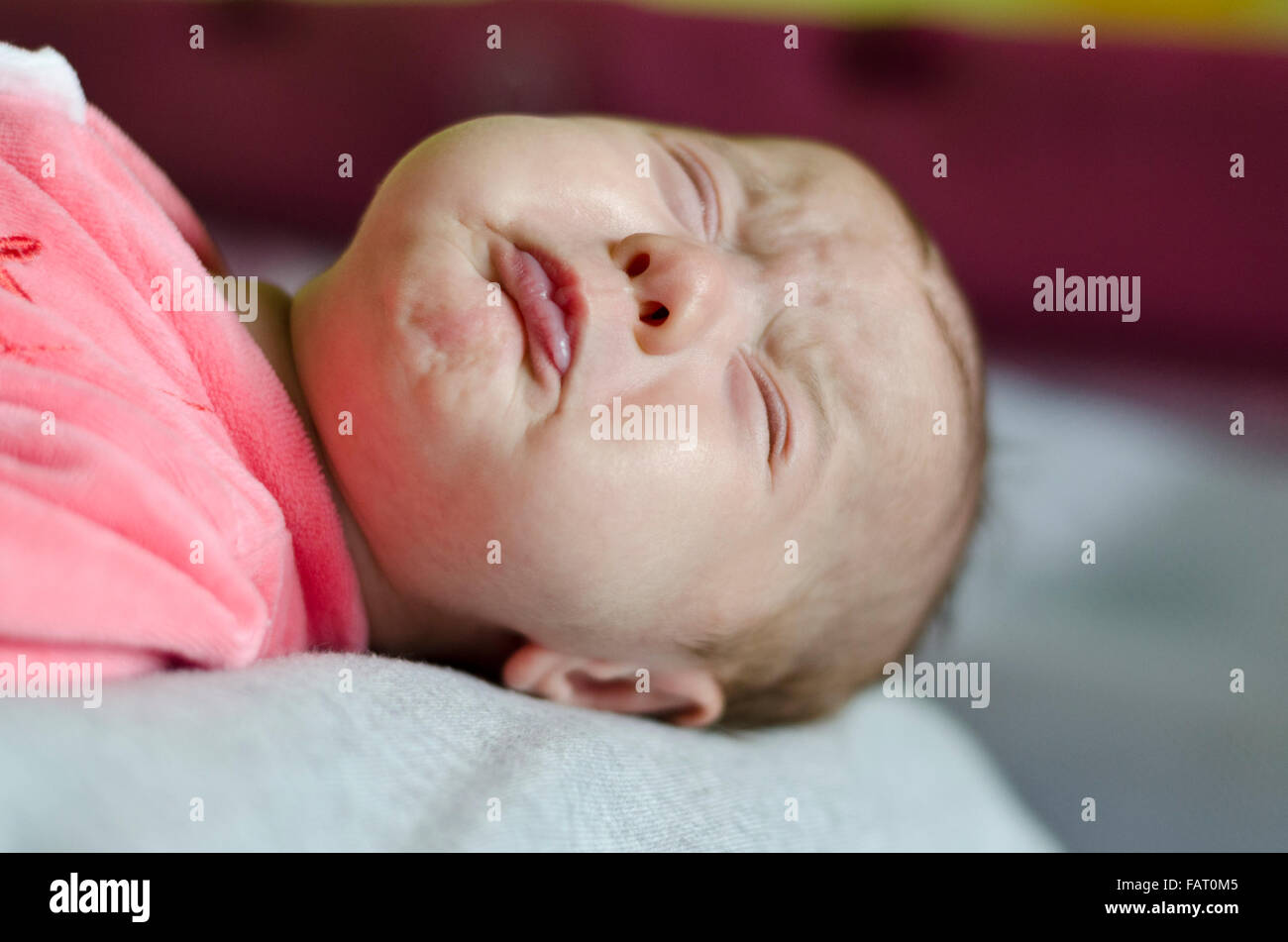 Un mignon petit bébé pleure dans le lit Banque D'Images