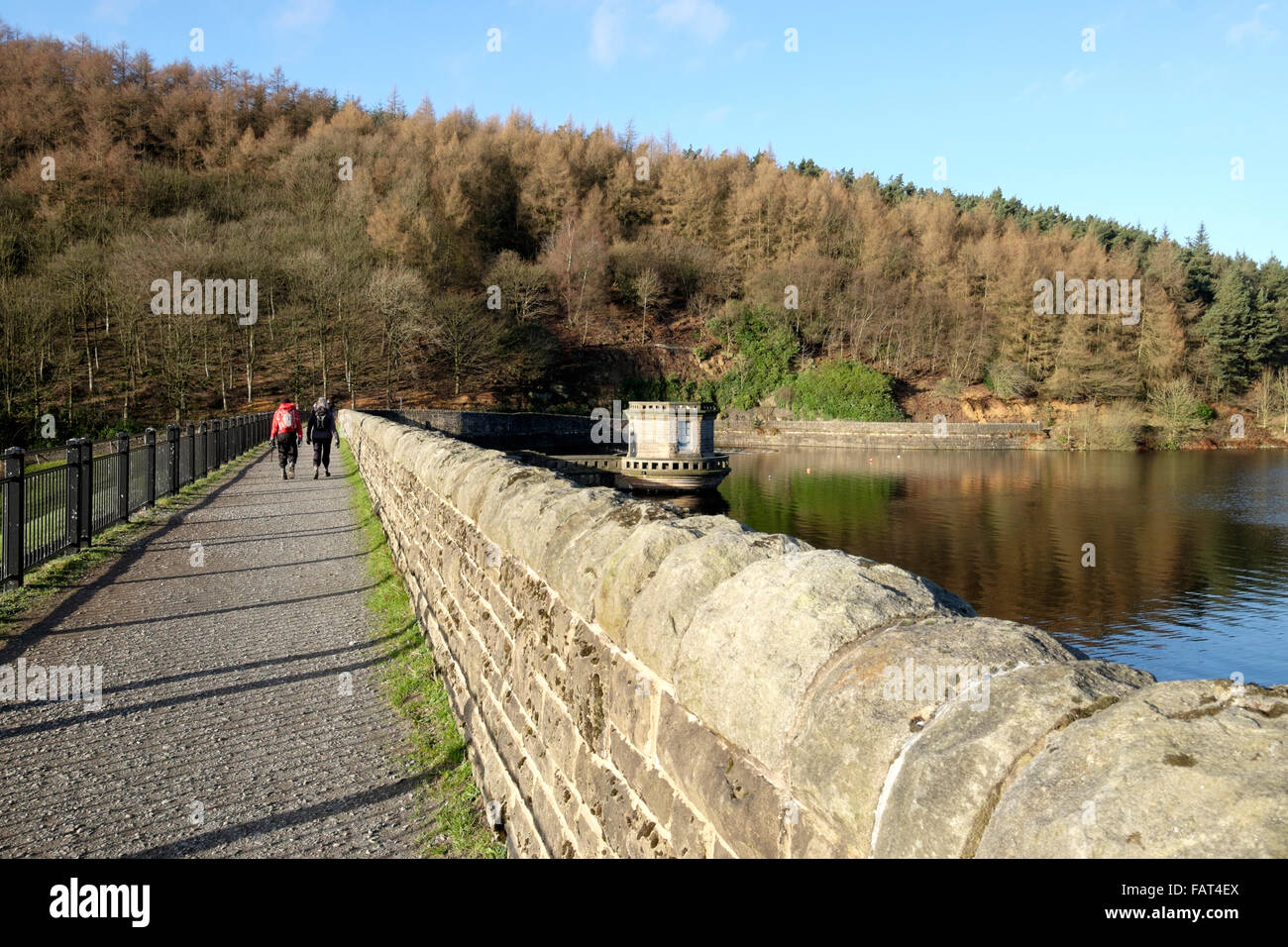 Deux personnes à pied le long du mur de barrage du Ladybower reservoir, La Vallée de Derwent, Derbyshire, Angleterre, RU Banque D'Images