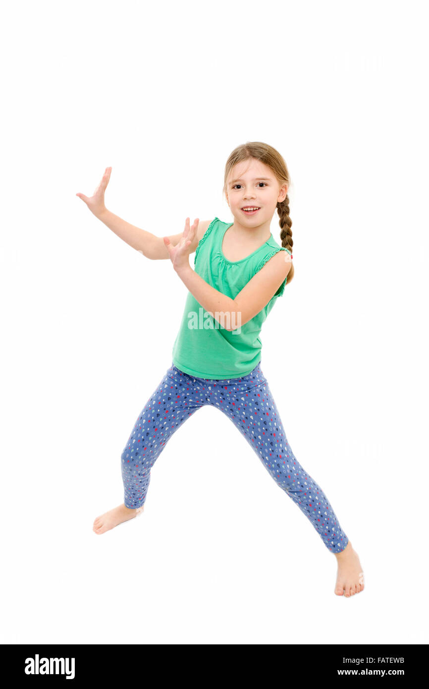 Young Girl wearing blue jambières et gilet vert dansant sur fond blanc Banque D'Images