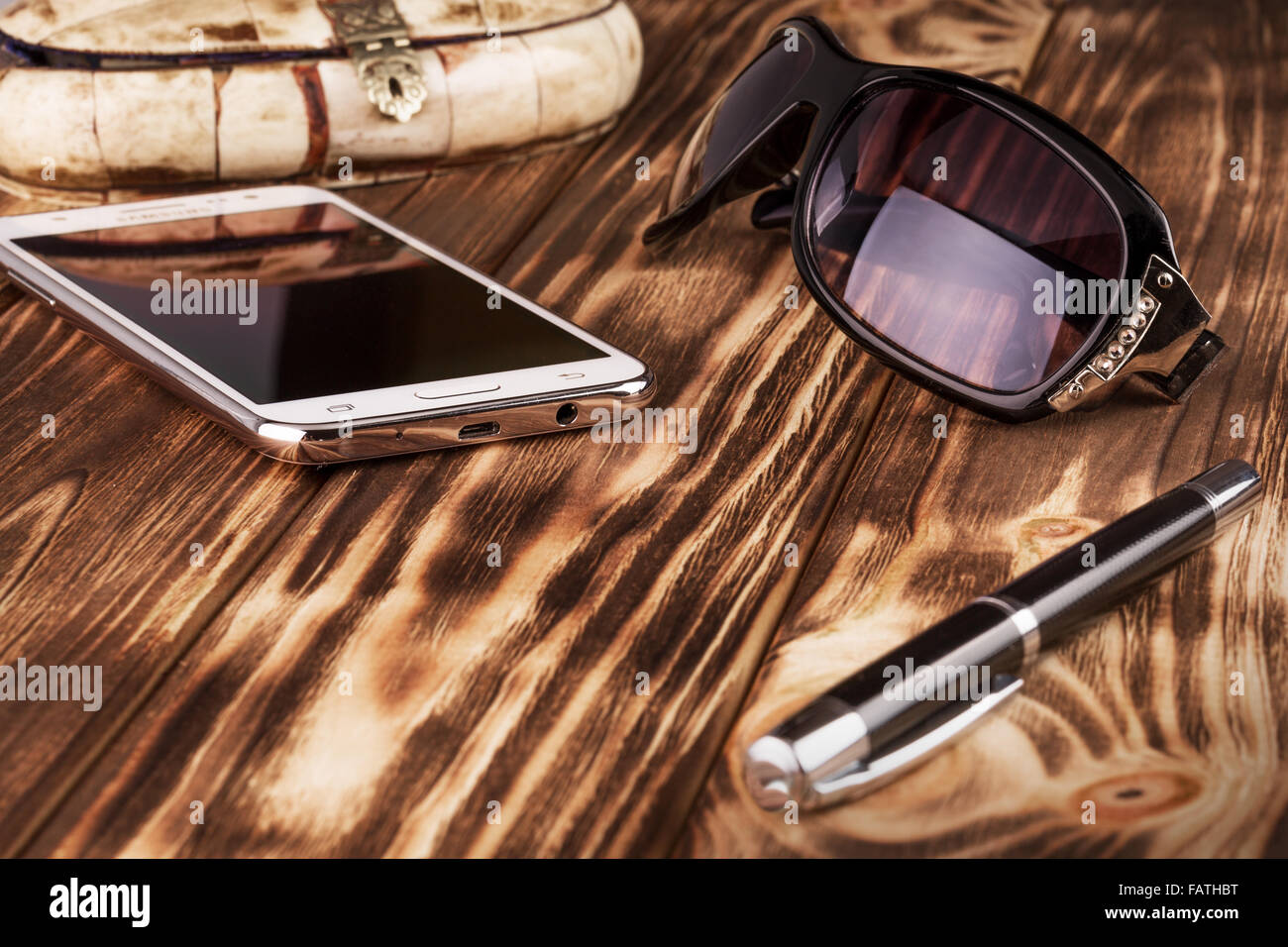 Téléphone mobile, pan et lunettes de soleil sur le fond de bois. Banque D'Images