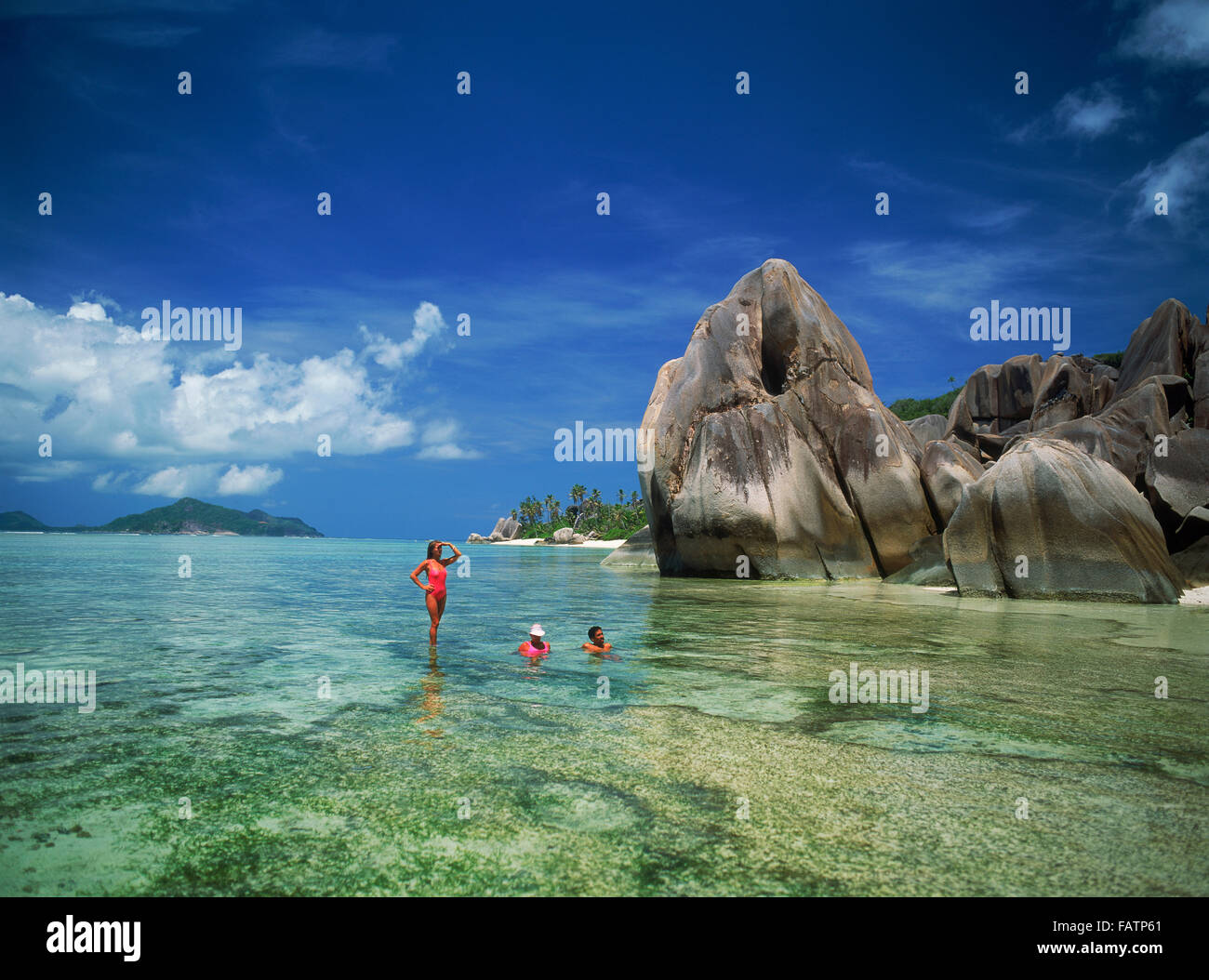 Couple in aqua eaux près de rochers de granit à l'Anse Source d'argent sur l'île de La Digue aux Seychelles Banque D'Images