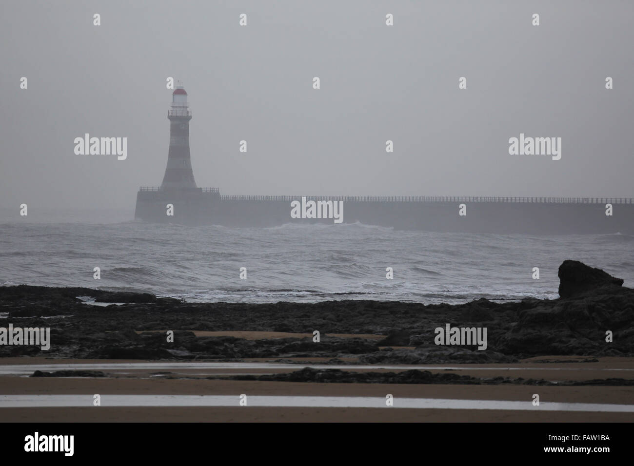 Roker Phare sur un jour d'hiver gris à Sunderland, en Angleterre. La jetée et le phare s'étendent dans la mer du Nord. Banque D'Images