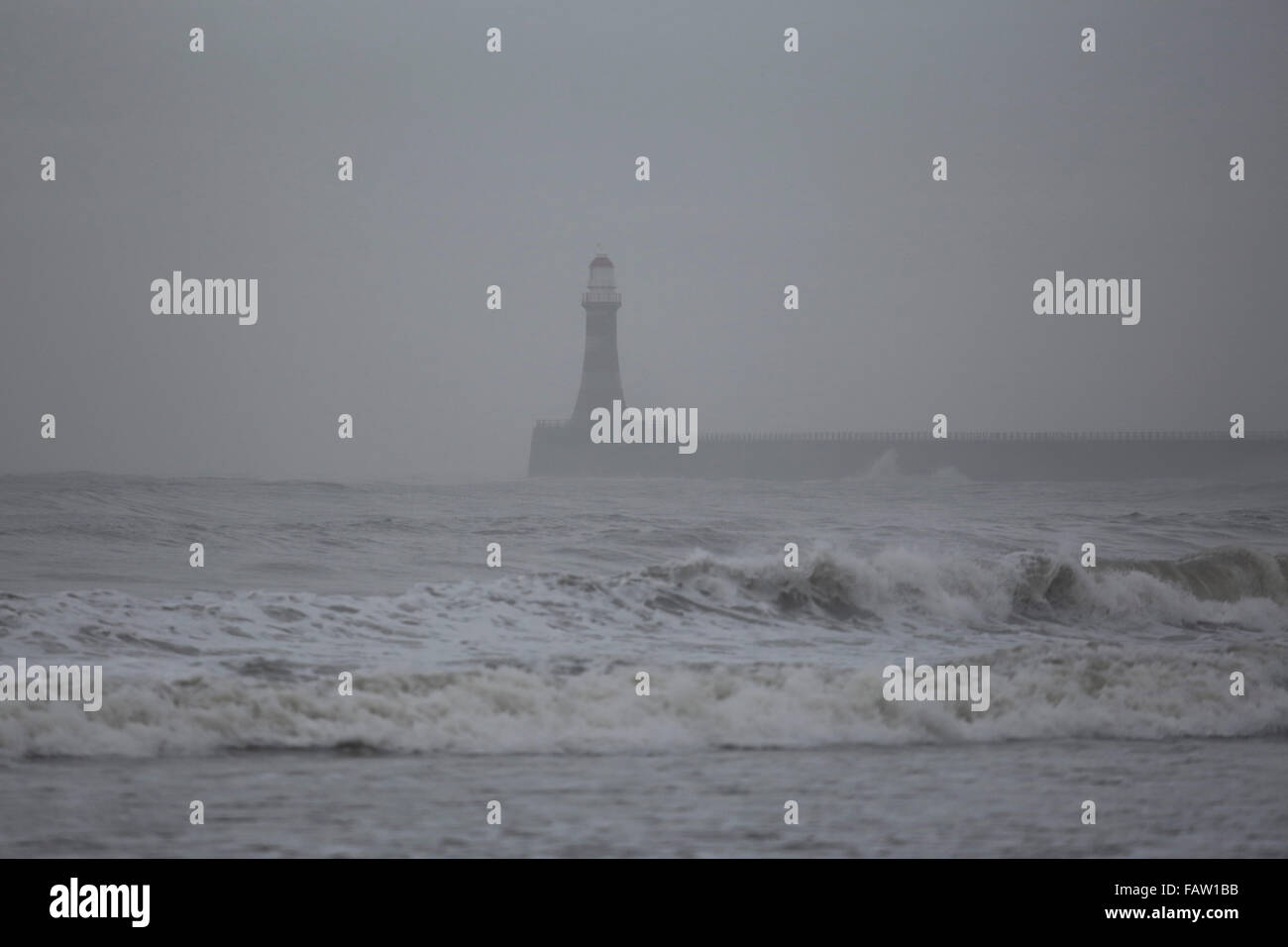 Roker phare sur une journée grise de la pluie à Sunderland, en Angleterre. La jetée et le phare s'étendent dans la mer du Nord. Banque D'Images