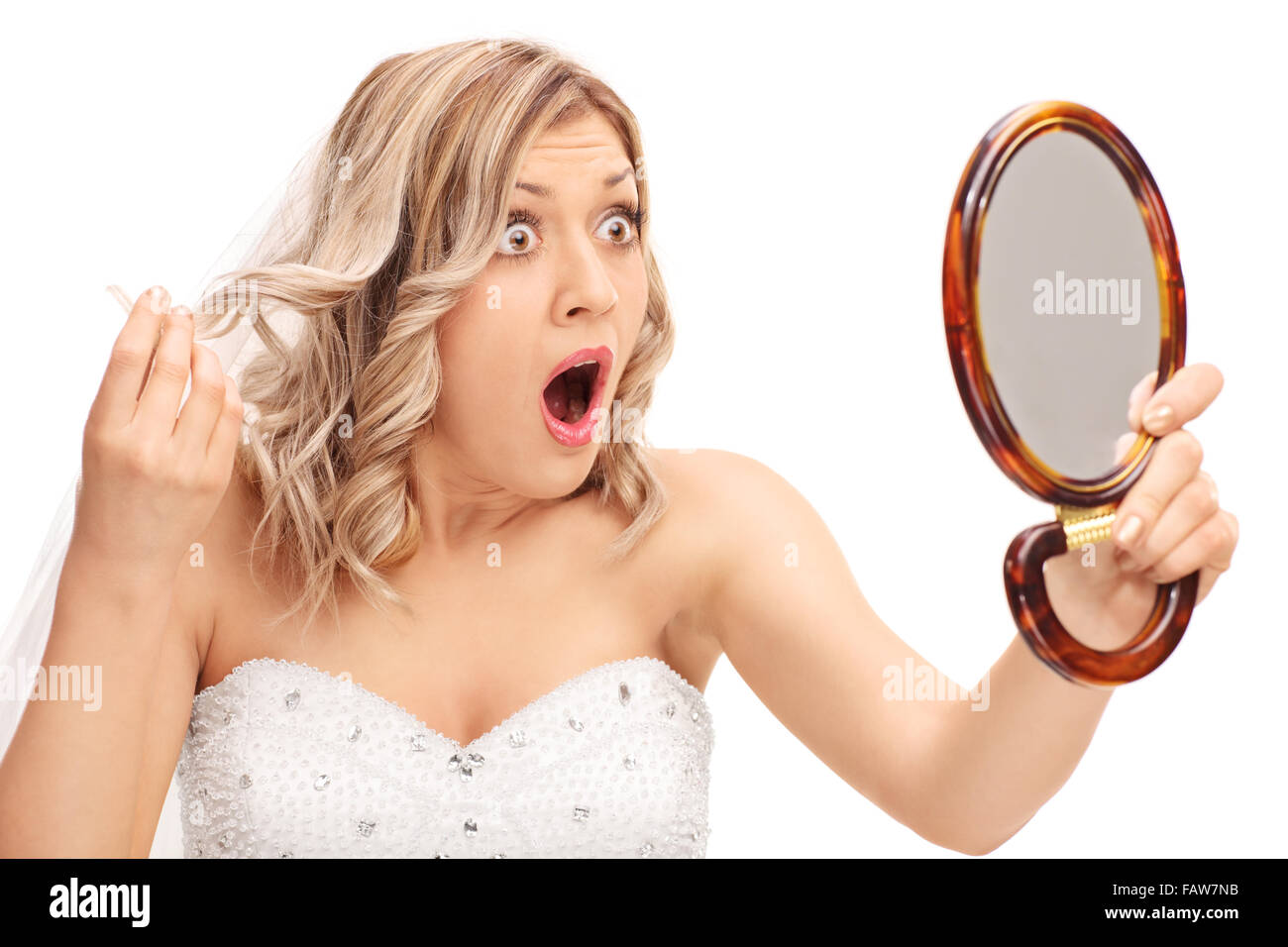 Les jeunes en colère à la mariée à sa coiffure dans un miroir isolé sur fond blanc Banque D'Images