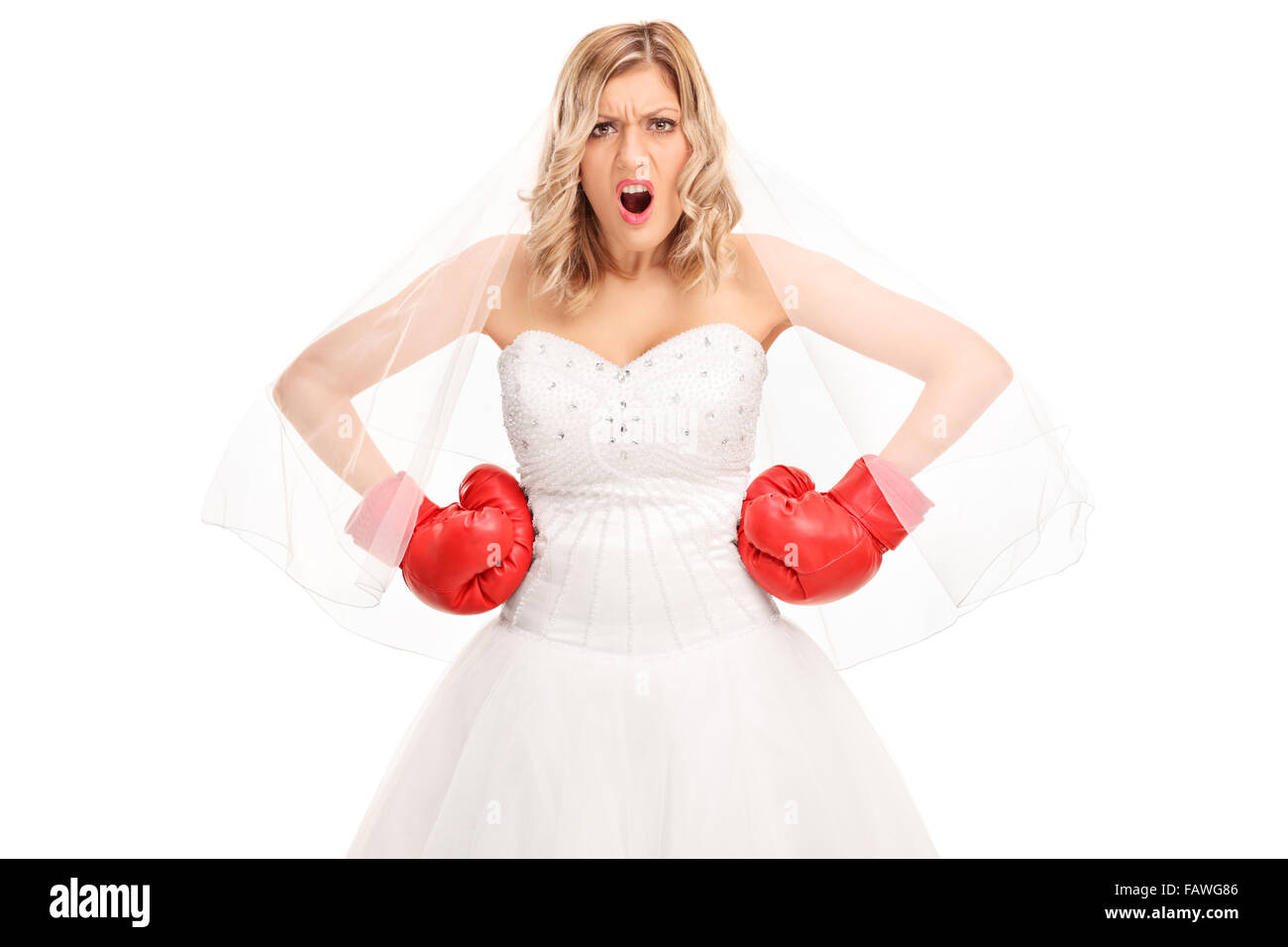 Mariée en colère dans une robe de mariée blanche et rouge gants de boxe regardant la caméra isolé sur fond blanc Banque D'Images