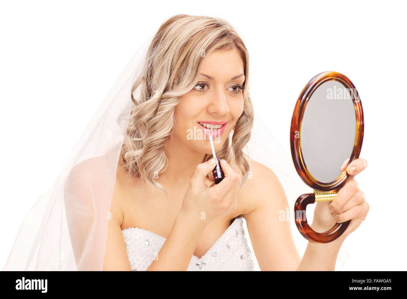 Young woman applying make-up et à la recherche dans un miroir isolé sur fond blanc Banque D'Images