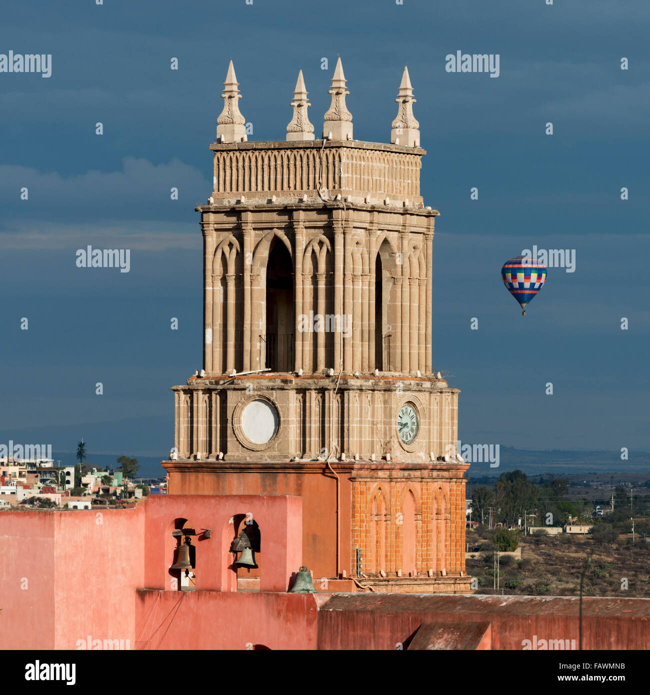 Tour de l'horloge et des cloches de l'église paroissiale avec un vol en montgolfière dans la distance ; San Miguel de Allende, Guanajuato, Mexique Banque D'Images