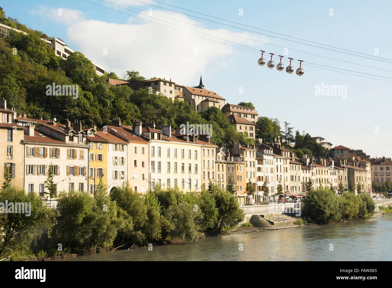 Télécabine de bulle au-dessus d'anciens bâtiments le long d'une rivière ; Grenoble, France Banque D'Images