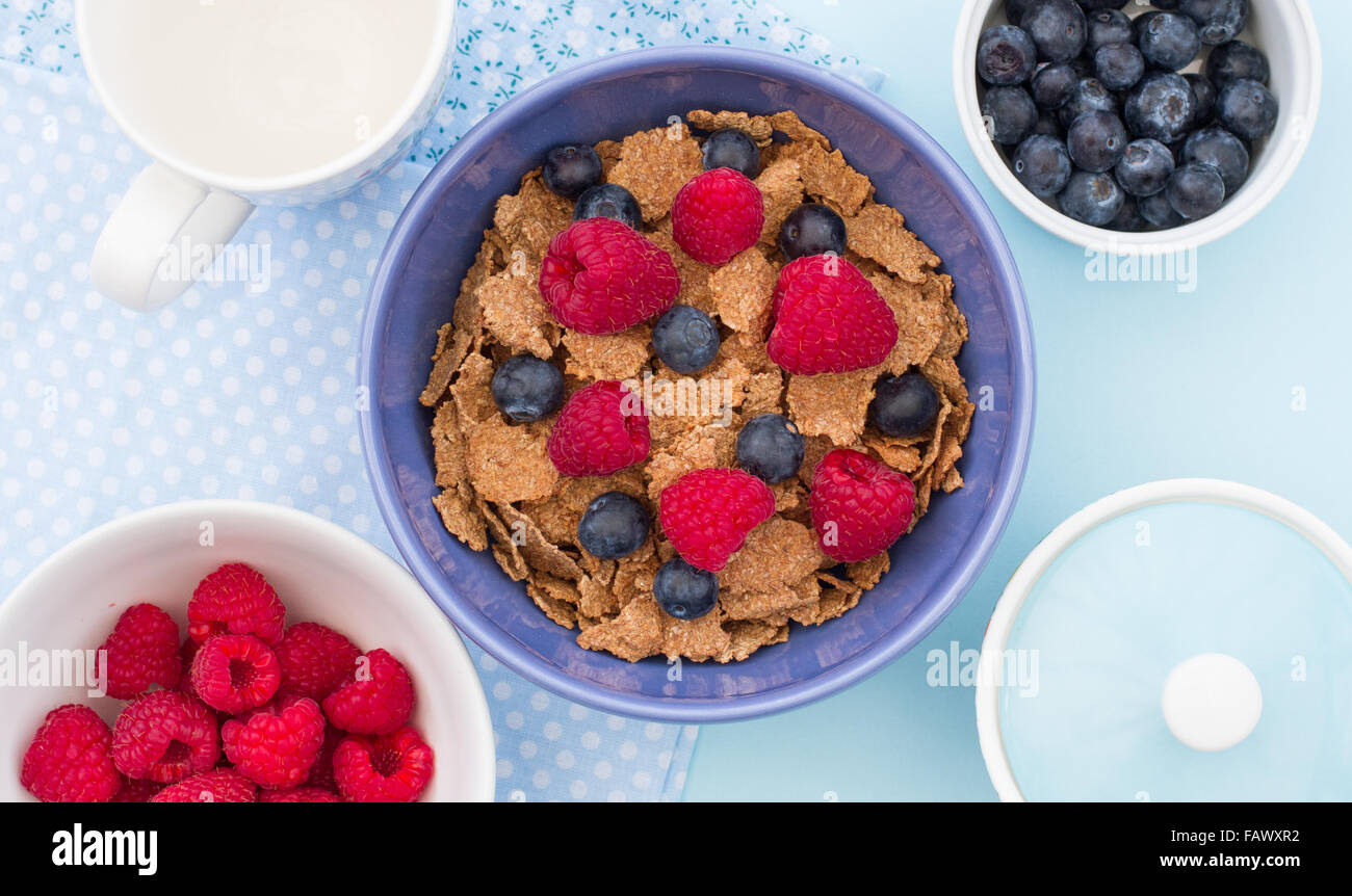 Un petit-déjeuner sain composé de céréales, de framboises et de bleuets. Tiré d'en haut à la recherche vers le bas sur la table. Banque D'Images