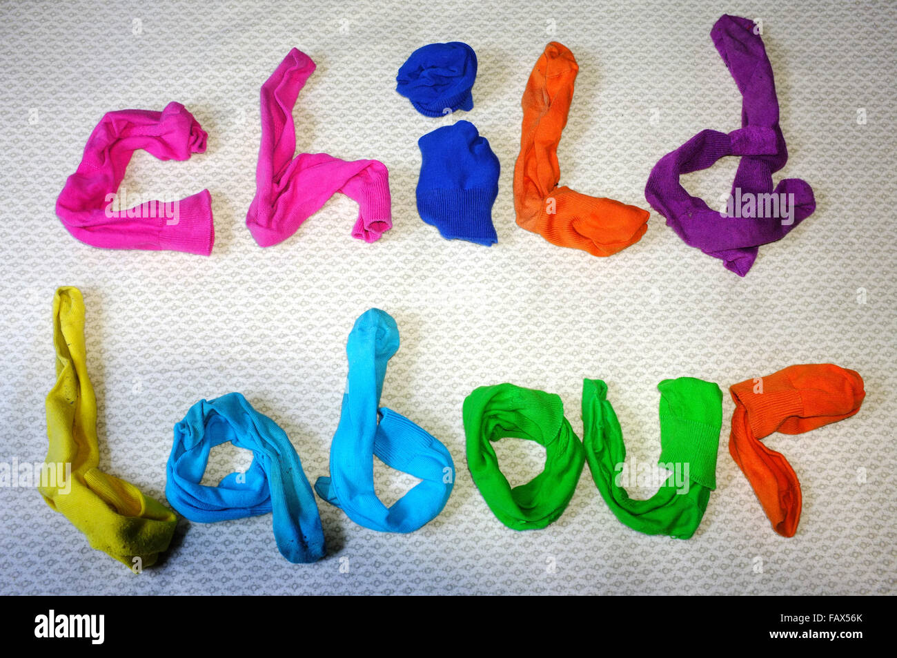 Les mots le travail des enfants fait de chaussettes colorées portant sur une couette. Banque D'Images
