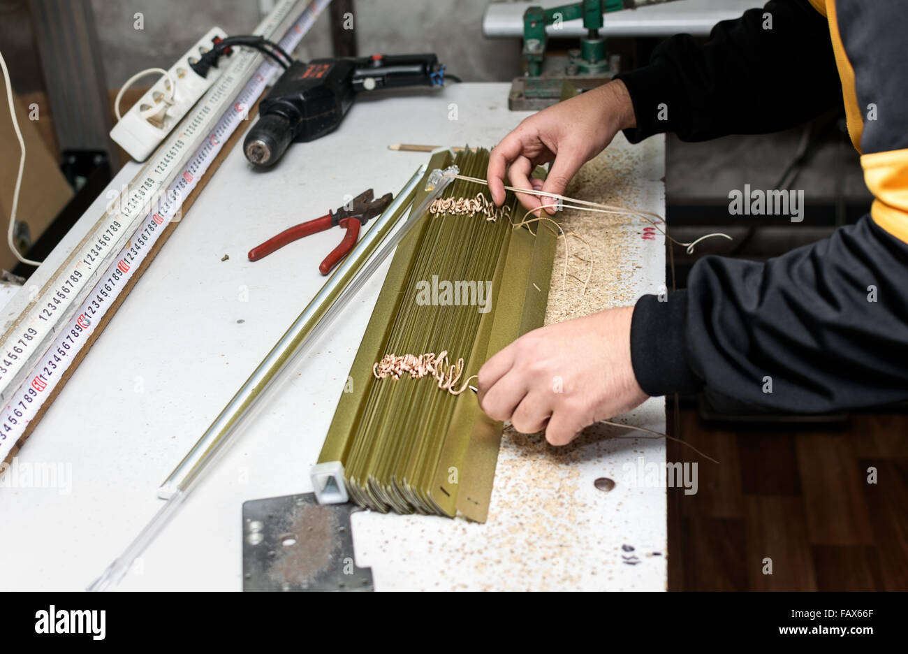 L'homme travaillant sur Venetian blind Assemblée générale à l'atelier de maison. Banque D'Images