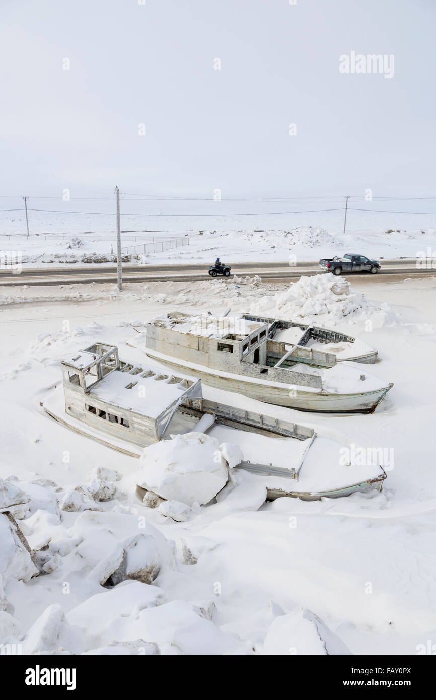 Les petits bateaux congelé dans les bancs de neige à côté d'une route, la glace de mer dans l'arrière-plan, Barrow, versant nord, l'Alaska arctique, USA, Hiver Banque D'Images