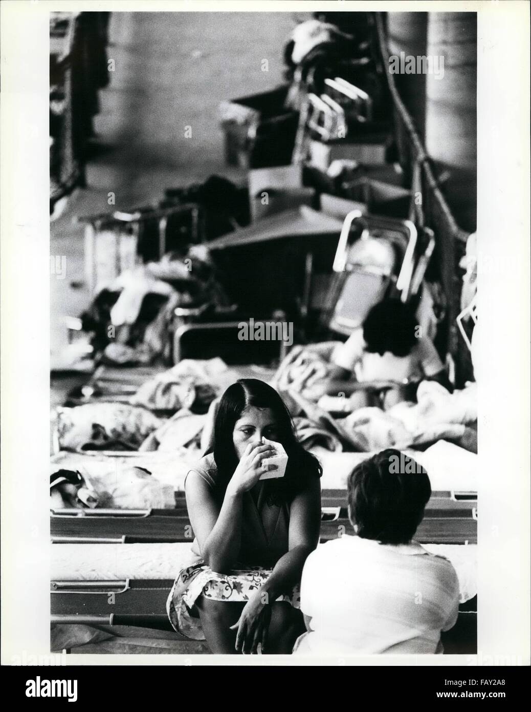 1972 Une Femme De Refugies Cubains Est Assise Sur Son Lit Bebe Sur Une Rampe Dans L Orange Bowl De Miami Comme Elle Boit Un Carton De Jus D Orange L Orange Bowl A