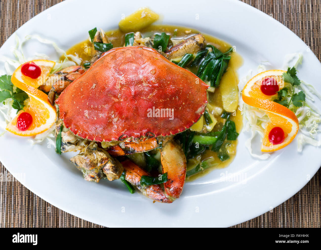 Angle de vue élevé fraîchement préparé ensemble un crabe dormeur en sauce à l'oignon vert sur plaque blanche. Banque D'Images