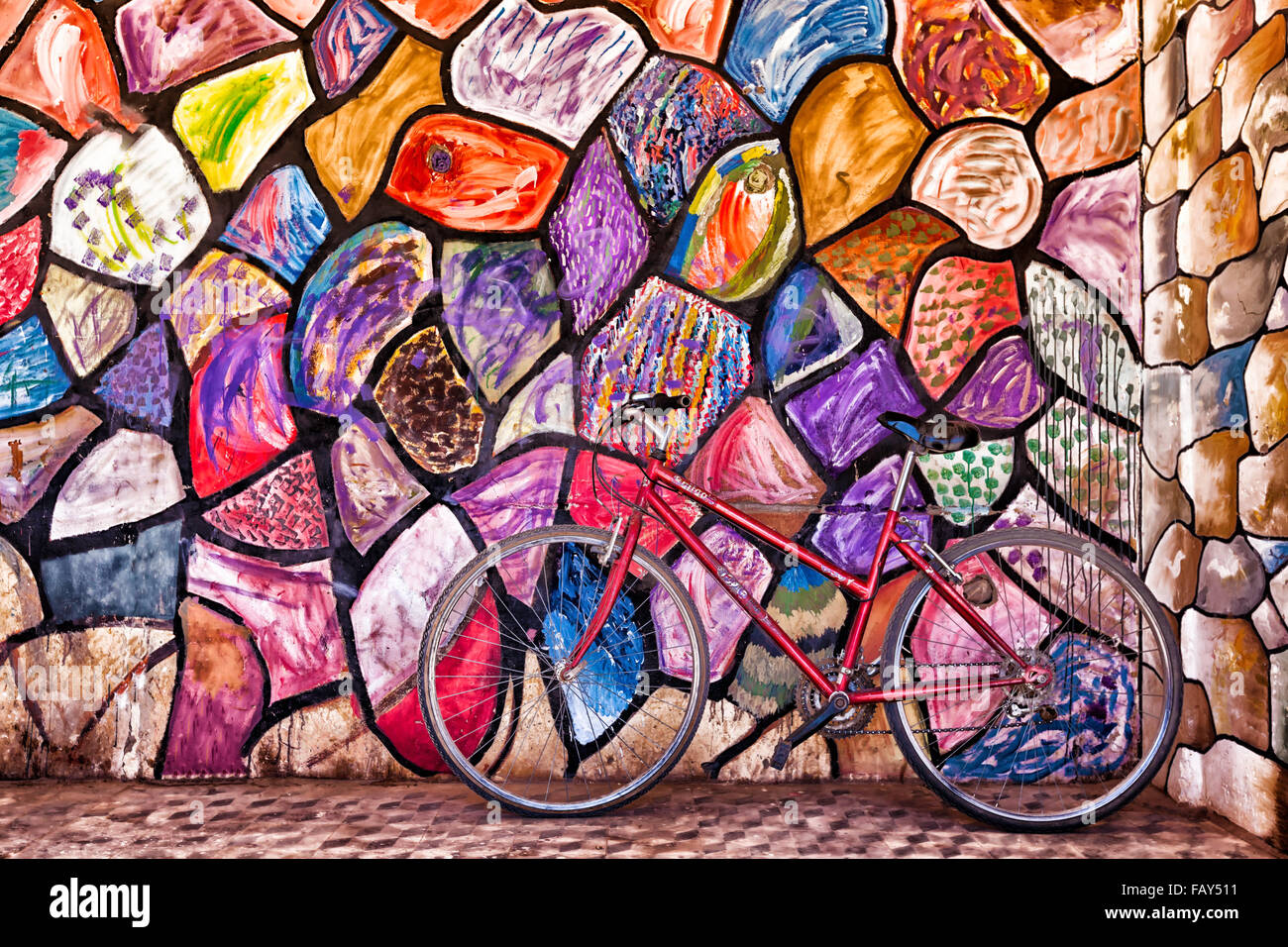 Vélo contre rouge, mur peint abstrait coloré. Banque D'Images