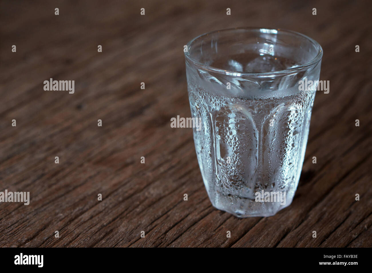 Verre d'eau froide sur la table en bois Banque D'Images