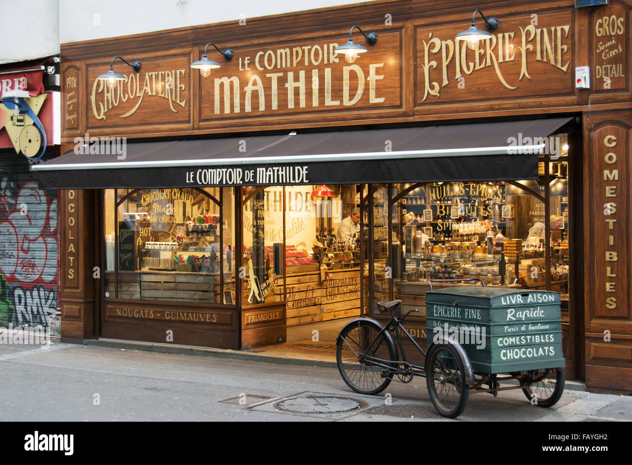La façade richement décorée d'un chocolat traditionnel avec un magasin panier Livraison en face ; Paris, France Banque D'Images
