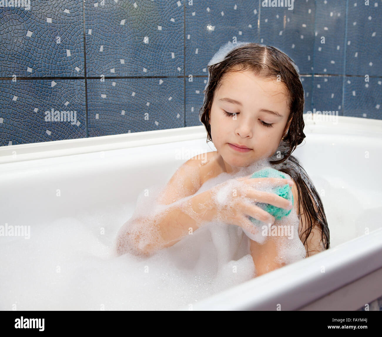 Petite fille lave-main avec éponge assis dans la baignoire libre Photo  Stock - Alamy