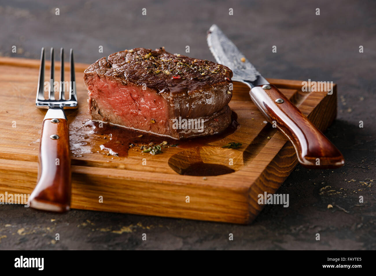 Bifteck de filet mignon sur planche de bois sur fond noir Photo Stock -  Alamy