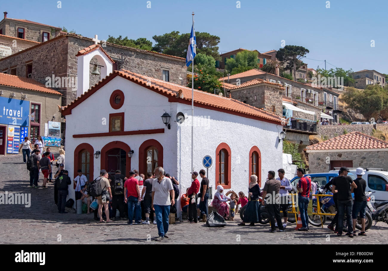 Réfugiés récemment arrivés de Syrie se rassembler devant une église orthodoxe grecque dans le port de Molyvos sur l'île de Lesbos Banque D'Images