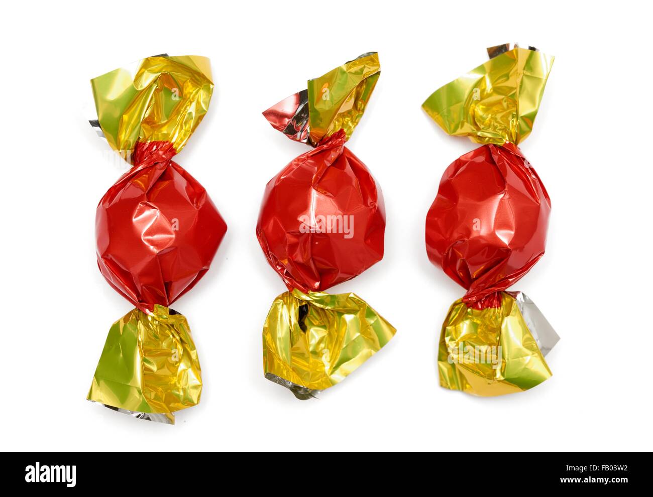 3 bonbons enveloppés dans des emballages de rouge et or Photo Stock - Alamy