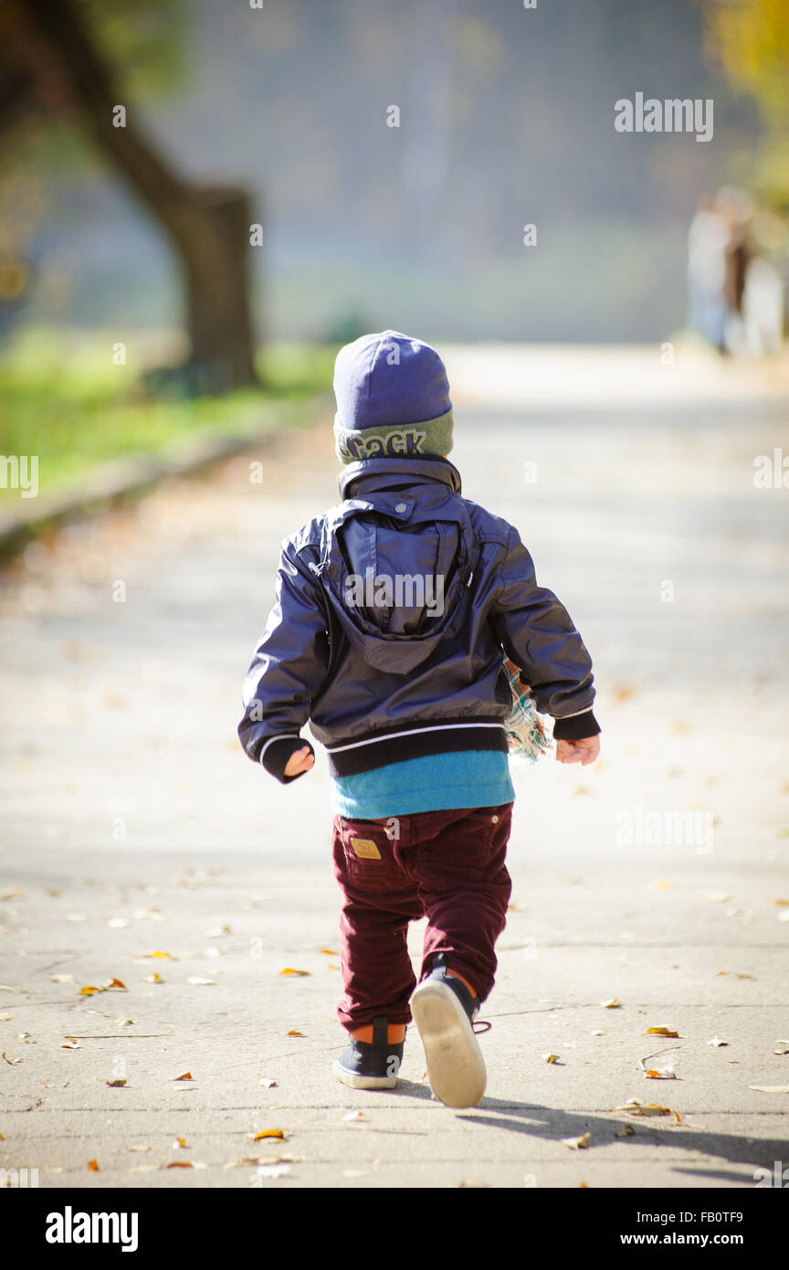 Petit garçon courir à Central Park l'été froid Banque D'Images