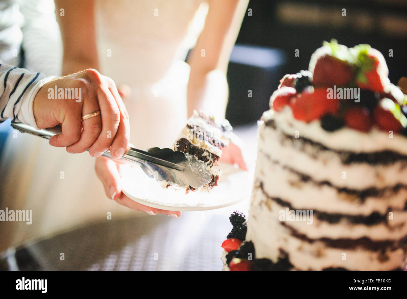 Mariée et le marié sont de trancher le gâteau de mariage à la réception Banque D'Images