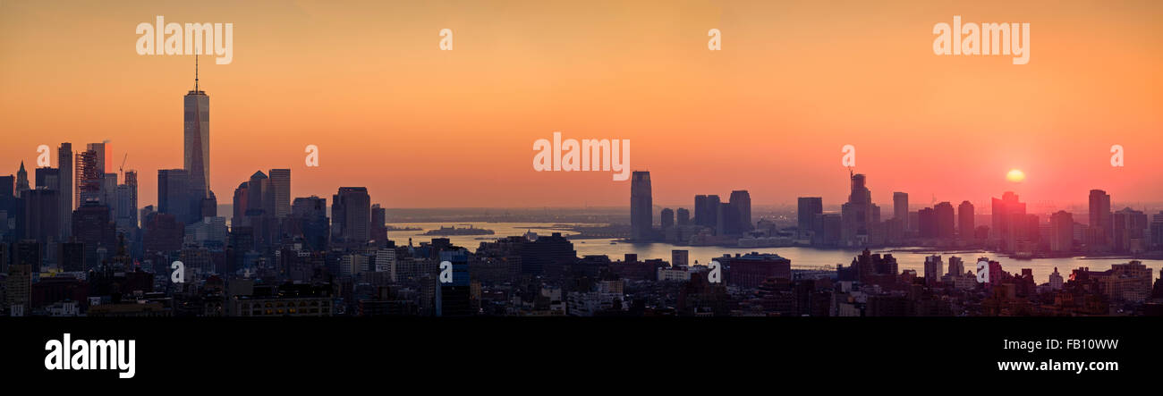 Waterfront cityscape sous golden sky at sunset Banque D'Images