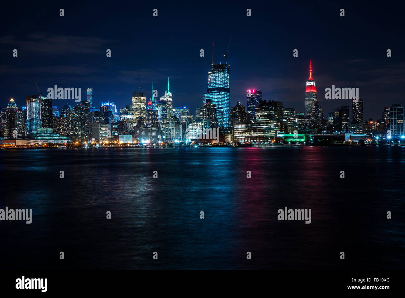 La ville illuminée se reflétant dans river Banque D'Images