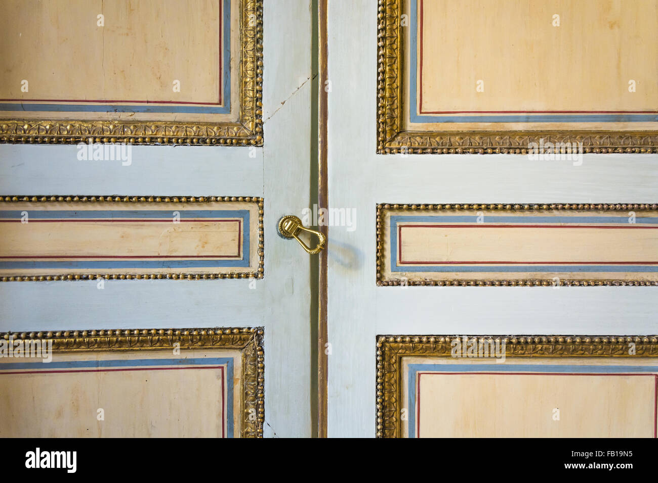 Une vieille porte peint décoré d'or, bleu et des lignes rouges Banque D'Images