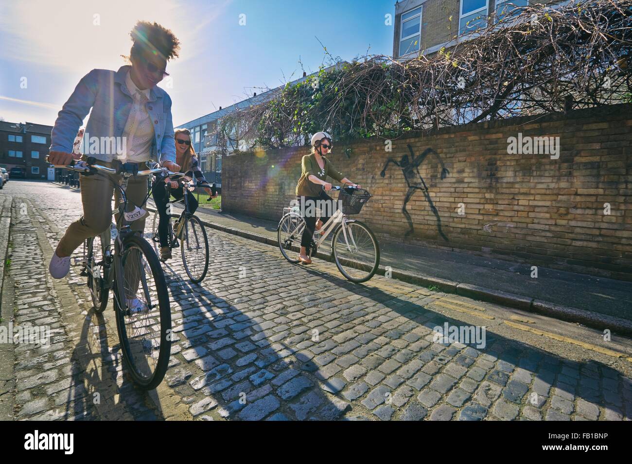 Vue en angle de la femme à vélo sur des vélos sur la route pavée Banque D'Images