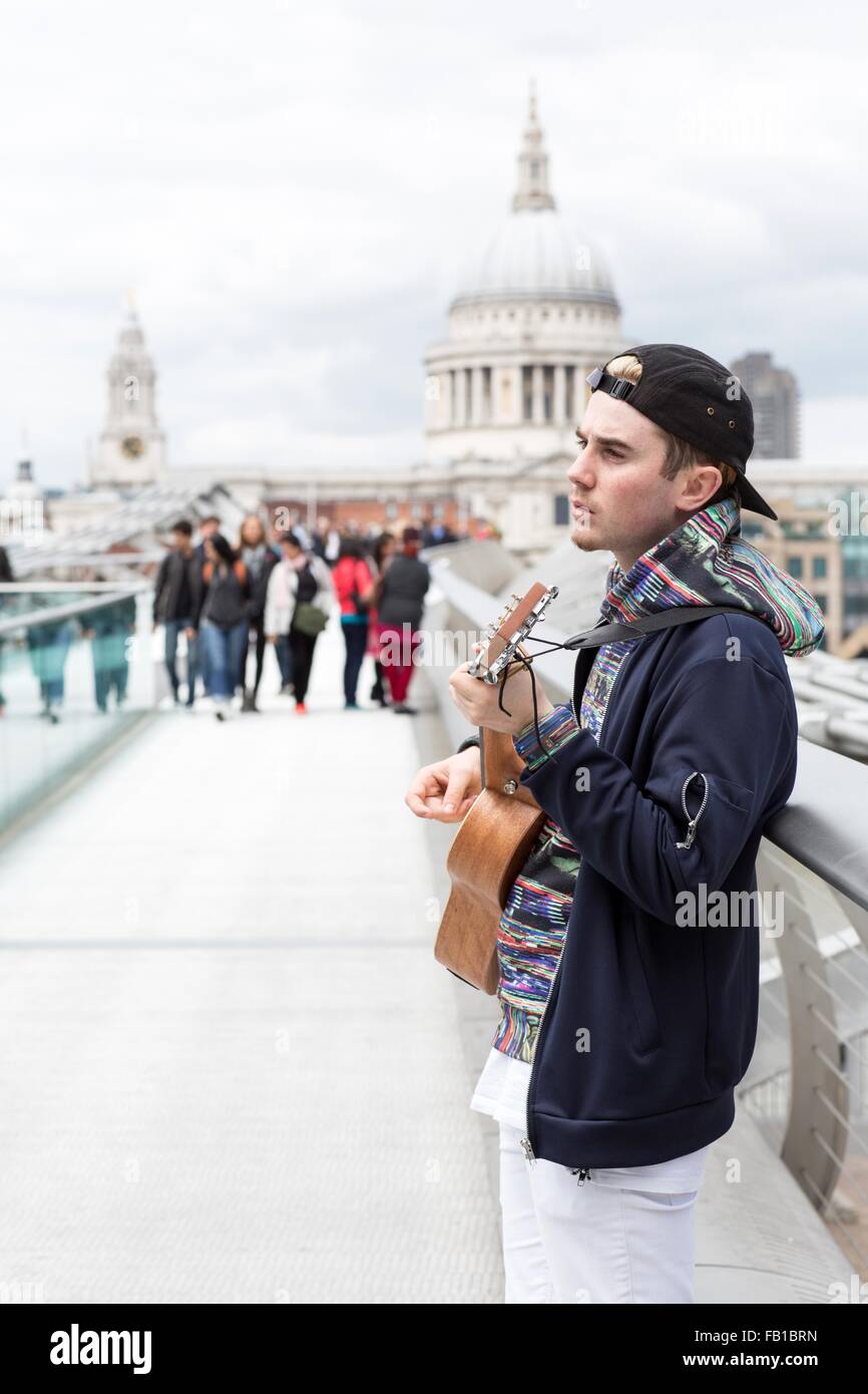 Jeune homme de la rue sur le Millennium Bridge, London, UK Banque D'Images