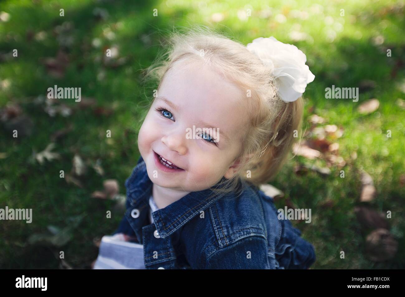 High angle portrait de fille avec fleur blanche accessoire cheveux veste en  jean à porter loin smiling Photo Stock - Alamy