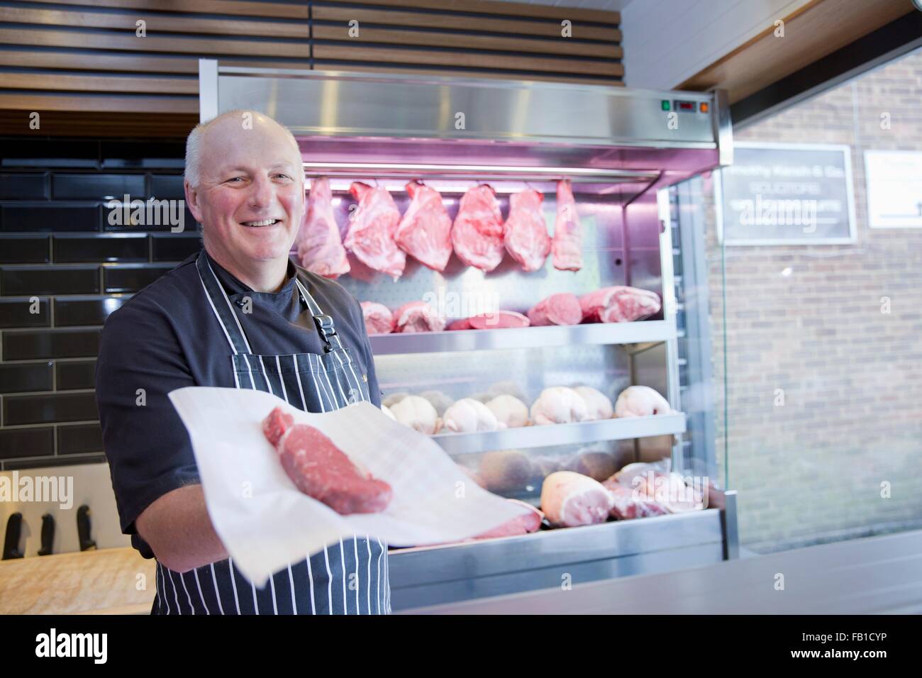 Portrait de butcher holding steak dans les boucheries shop Banque D'Images