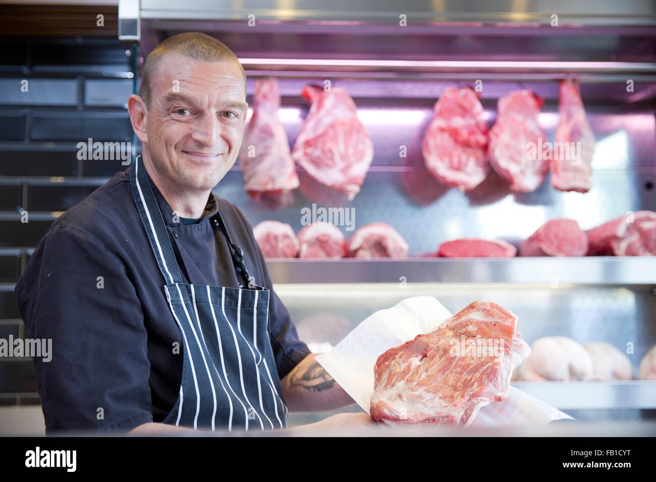 Portrait de butcher holding la viande fraîche en bouchers shop Banque D'Images